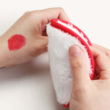 Cleansing face puff being used to remove red makeup stain from a hand, showcasing 4-pack sponge makeup removers.
