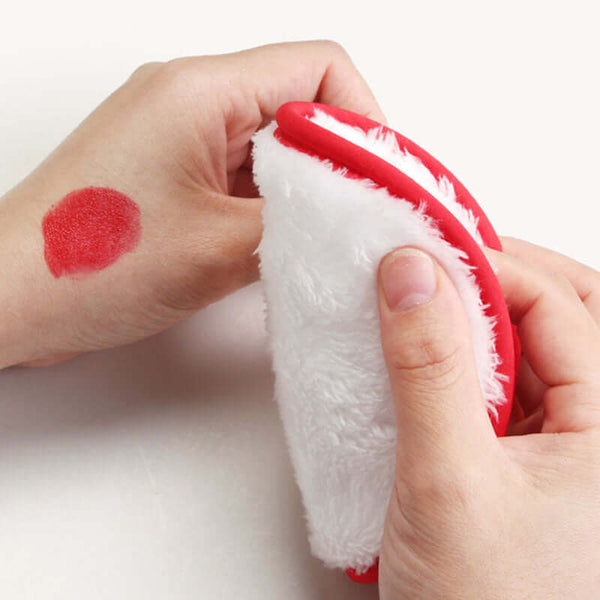 Cleansing face puff being used to remove red makeup stain from a hand, showcasing 4-pack sponge makeup removers.