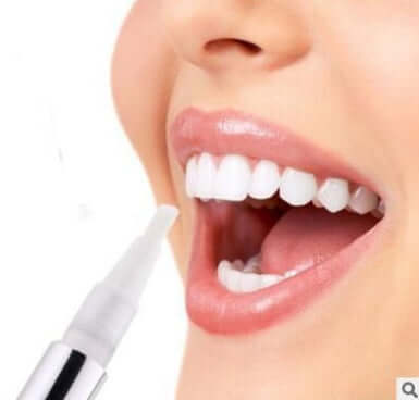 Close-up of a person applying a teeth whitening pen for a brighter smile and stain removal.